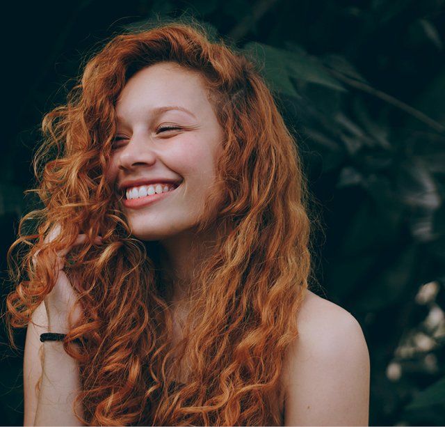 Smiling woman with curly red hair